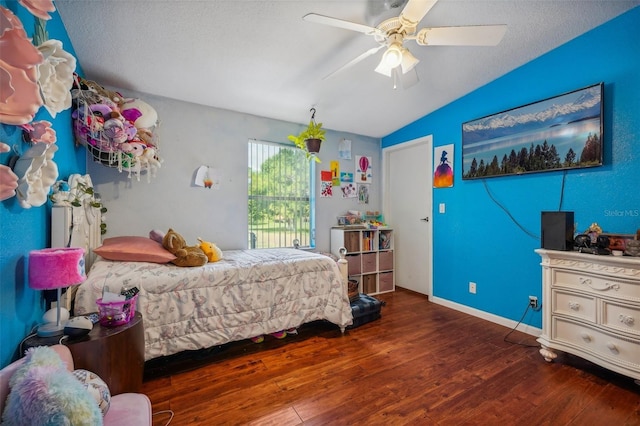 bedroom featuring lofted ceiling, a textured ceiling, dark wood-type flooring, a ceiling fan, and baseboards