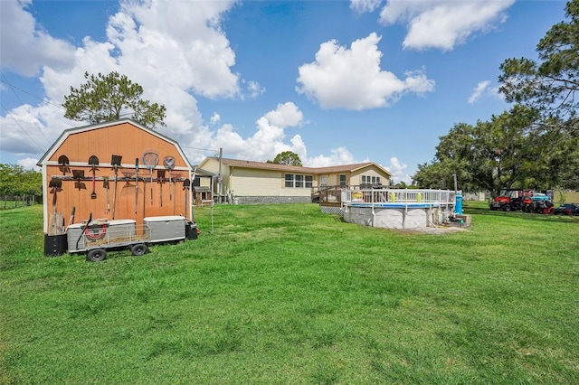 rear view of house with a yard and an outdoor pool