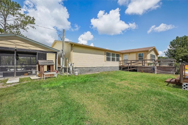 back of property featuring a lawn and a sunroom