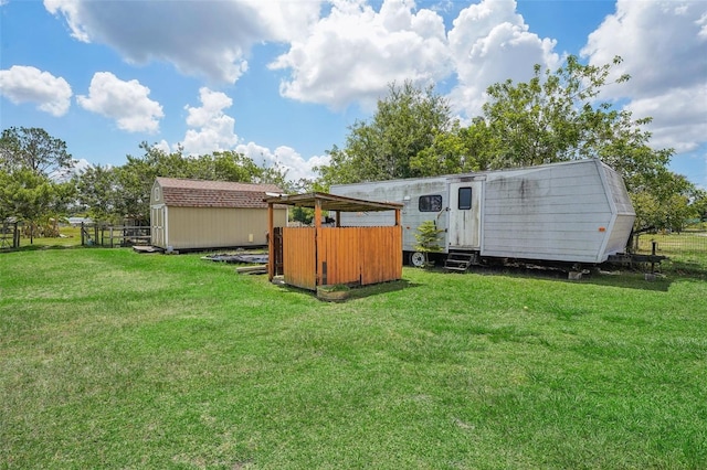 back of house featuring a shed, an outbuilding, and a yard