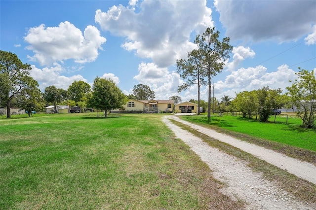 view of front of property featuring driveway, fence, and a front yard