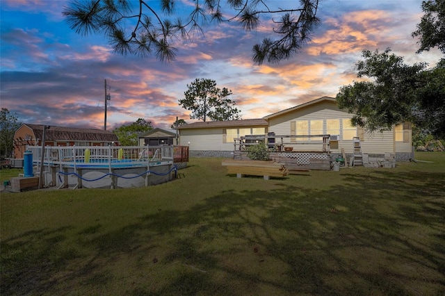 yard at dusk with an outdoor pool and a wooden deck