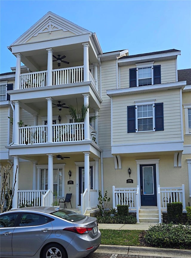 view of front facade with a ceiling fan, covered porch, and stucco siding