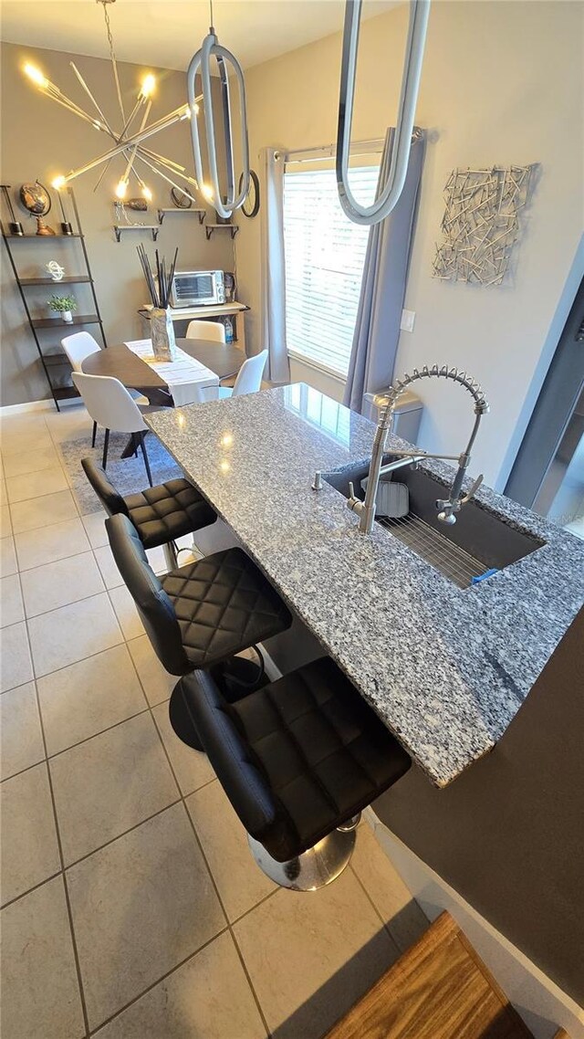 136 Mcleods Way, Winter Springs, FL 32708 - kitchen with a sink, tile patterned floors, stone countertops, a chandelier, and hanging light fixtures