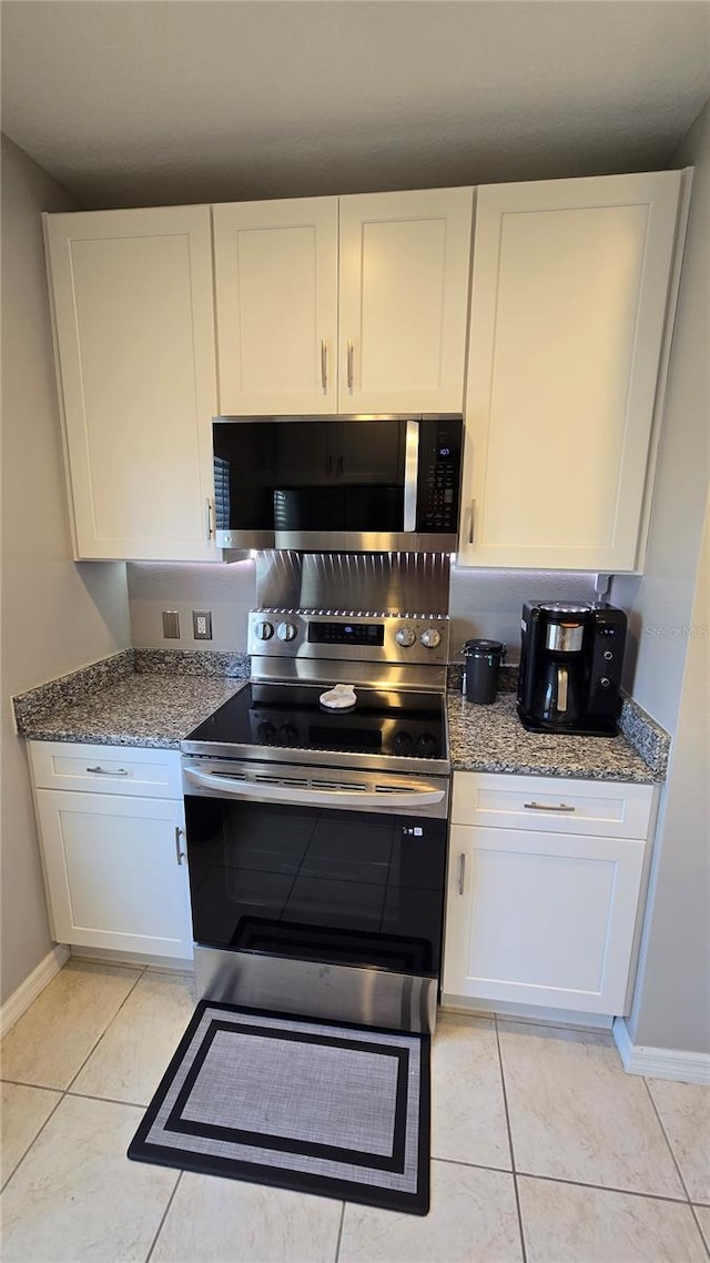 136 Mcleods Way, Winter Springs, FL 32708 - kitchen with stainless steel appliances, light tile patterned flooring, white cabinets, and baseboards