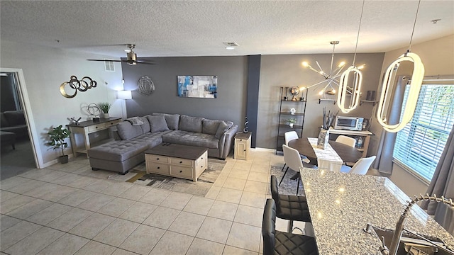 136 Mcleods Way, Winter Springs, FL 32708 - living area with light tile patterned floors, a chandelier, ceiling fan, a textured ceiling, and baseboards