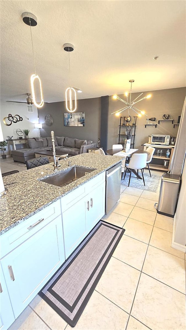 136 Mcleods Way, Winter Springs, FL 32708 - kitchen with dishwasher, a sink, stone counters, open floor plan, and a textured ceiling