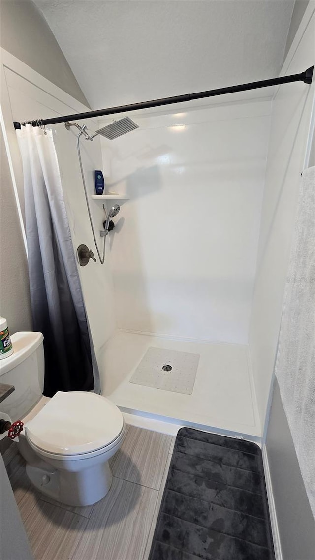 136 Mcleods Way, Winter Springs, FL 32708 - bathroom with a stall shower, toilet, lofted ceiling, and tile patterned flooring