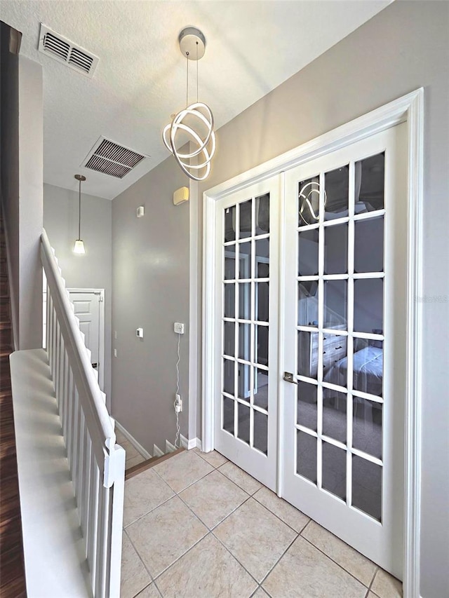 136 Mcleods Way, Winter Springs, FL 32708 - entryway with french doors, light tile patterned floors, baseboards, a textured ceiling, and stairway