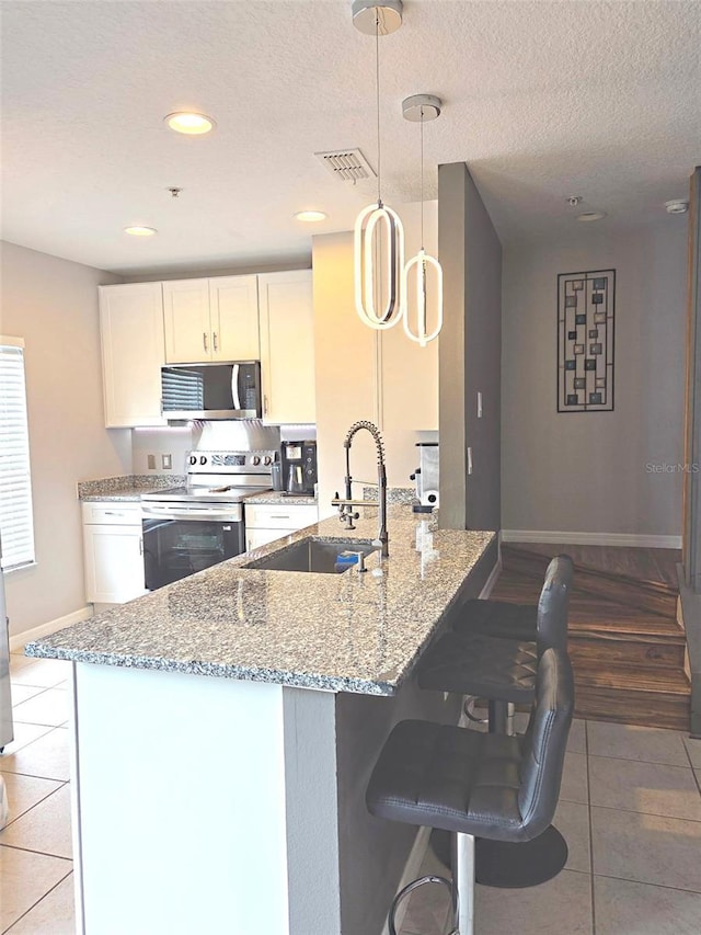 136 Mcleods Way, Winter Springs, FL 32708 - kitchen with stainless steel appliances, a sink, light tile patterned flooring, baseboards, and light stone counters