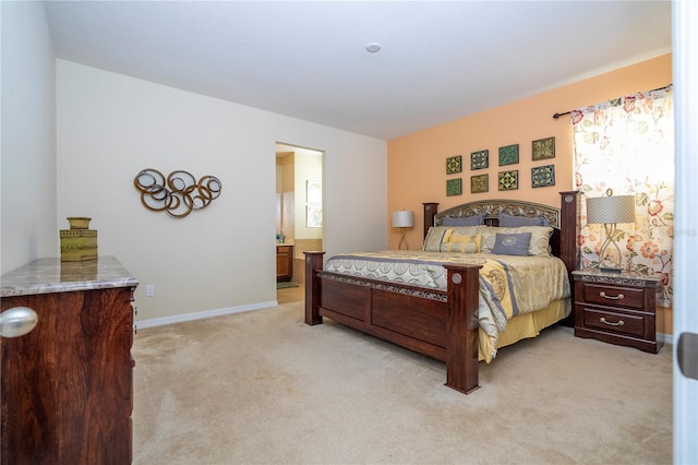 bedroom with light carpet, baseboards, and ensuite bathroom