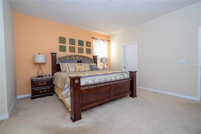 bedroom with light colored carpet and baseboards