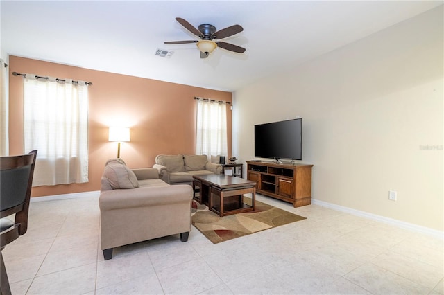 living room featuring a ceiling fan, a wealth of natural light, visible vents, and baseboards