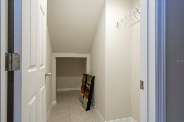 corridor with a textured ceiling and baseboards