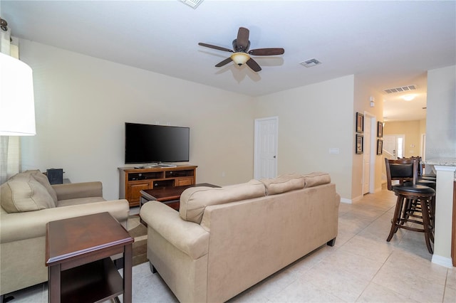 living area with baseboards, light tile patterned flooring, visible vents, and a ceiling fan