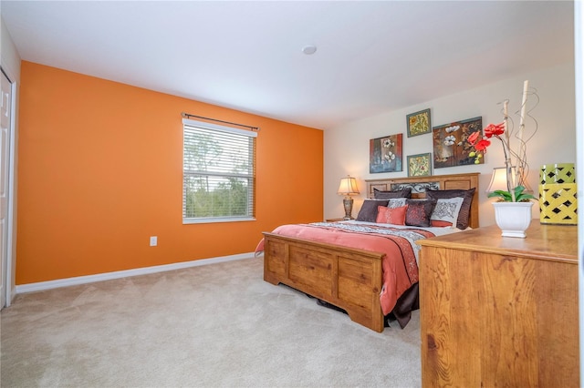 bedroom with light carpet and baseboards