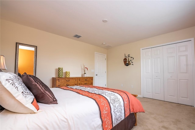 bedroom with a closet, light carpet, and visible vents