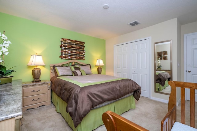 bedroom featuring a closet, visible vents, and light colored carpet