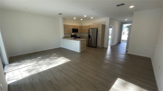 kitchen with appliances with stainless steel finishes, dark hardwood / wood-style floors, and kitchen peninsula