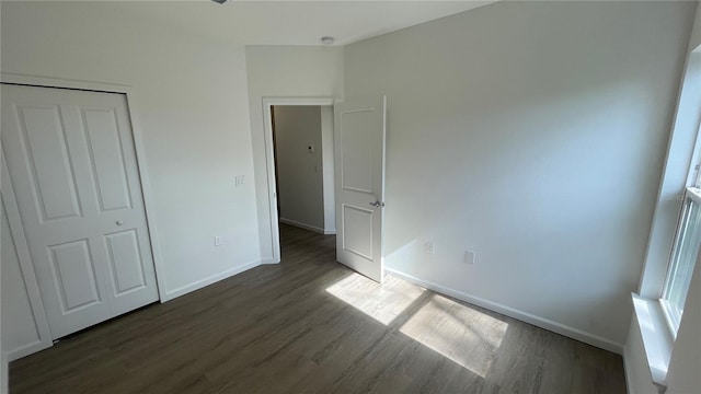 unfurnished bedroom with dark hardwood / wood-style flooring