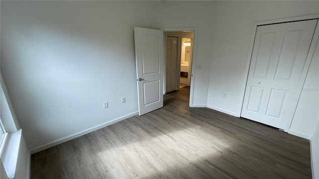 unfurnished bedroom featuring dark wood-type flooring and a closet