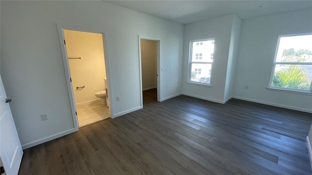 unfurnished bedroom featuring dark hardwood / wood-style floors and ensuite bathroom