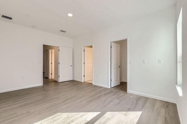 unfurnished bedroom featuring light wood-style flooring, visible vents, and baseboards