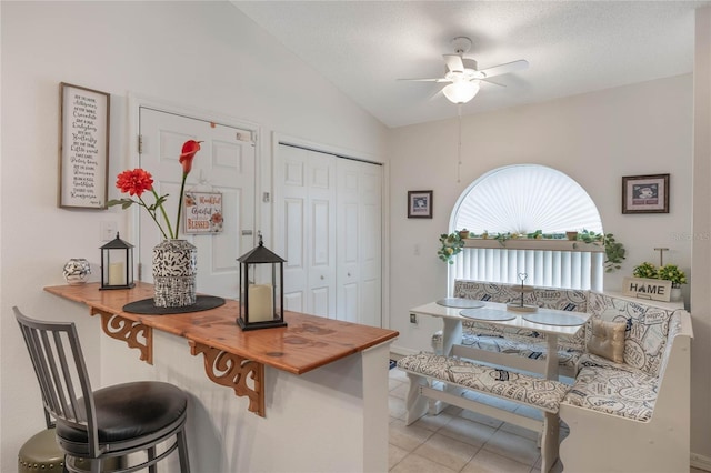 130 Bloomingdale Dr, Davenport, FL 33897 - kitchen with a ceiling fan, tile patterned flooring, vaulted ceiling, and a breakfast bar