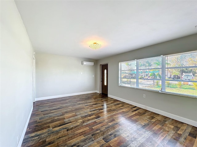 unfurnished room featuring an AC wall unit and dark hardwood / wood-style flooring