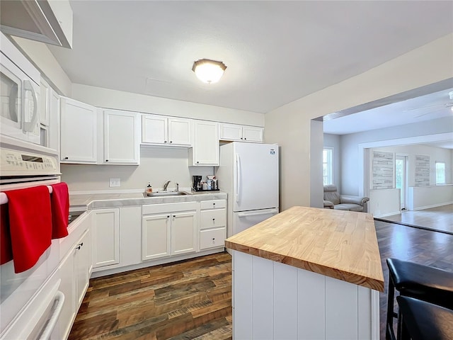 kitchen with white cabinetry, white appliances, dark hardwood / wood-style flooring, and butcher block counters