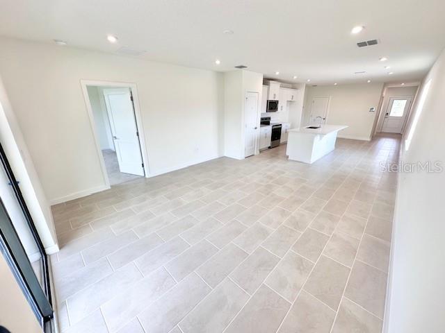 3225 Cup Dr, Lakeland, FL 33803 - unfurnished living room with recessed lighting and baseboards