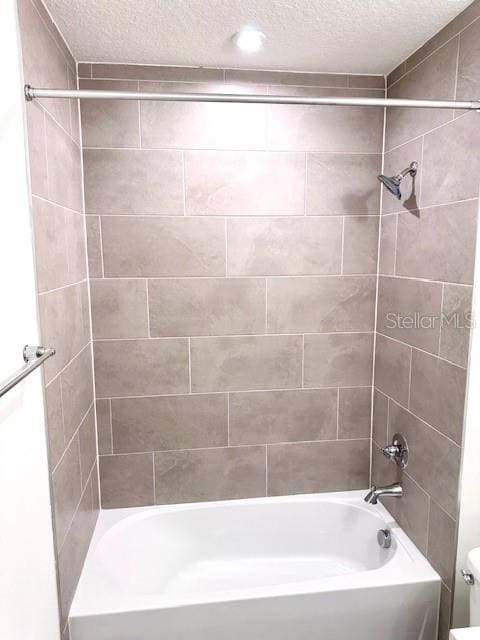 3225 Cup Dr, Lakeland, FL 33803 - bathroom with a textured ceiling, shower / tub combination, and toilet