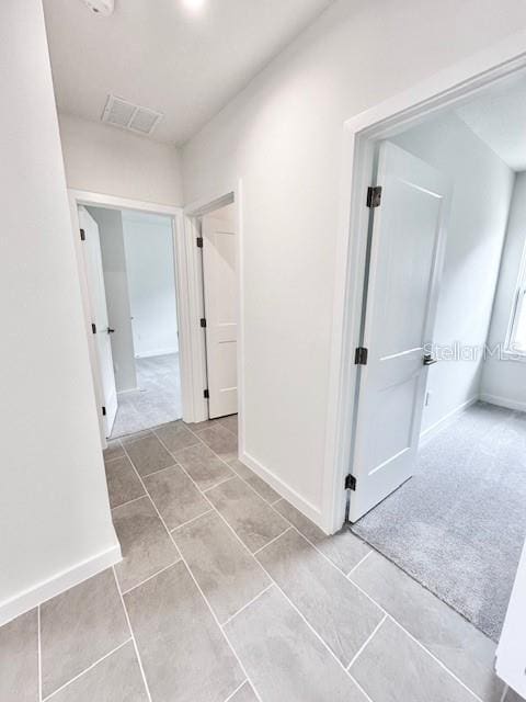 3225 Cup Dr, Lakeland, FL 33803 - hall with baseboards, tile patterned floors, and carpet flooring