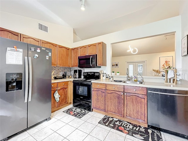 kitchen featuring a sink, visible vents, vaulted ceiling, light countertops, and appliances with stainless steel finishes