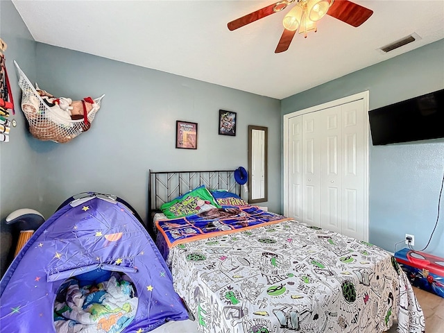 bedroom with ceiling fan, visible vents, and a closet