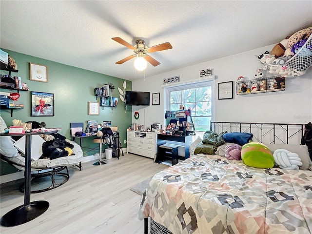 bedroom with a textured ceiling, ceiling fan, and wood finished floors