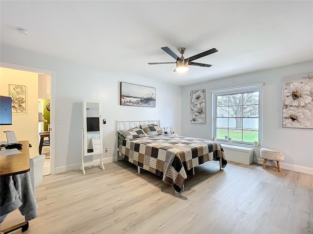 bedroom featuring a ceiling fan, baseboards, and light wood finished floors