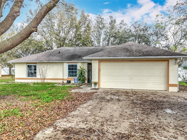 ranch-style house featuring a garage, driveway, a shingled roof, and stucco siding