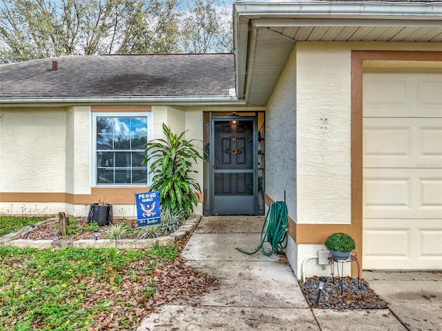 doorway to property featuring a shingled roof and stucco siding