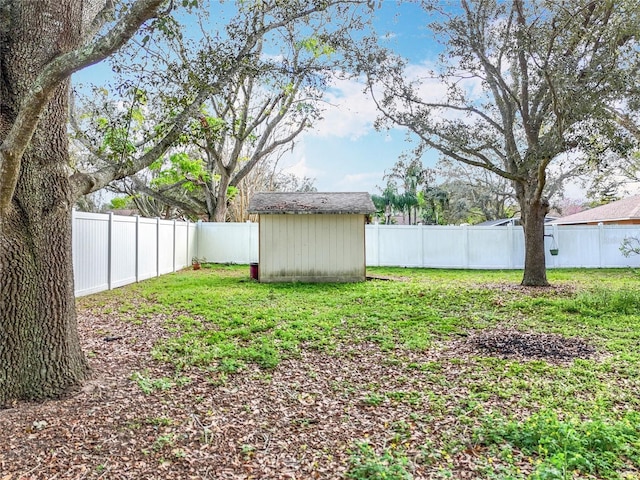 view of yard featuring a storage shed, an outdoor structure, and a fenced backyard