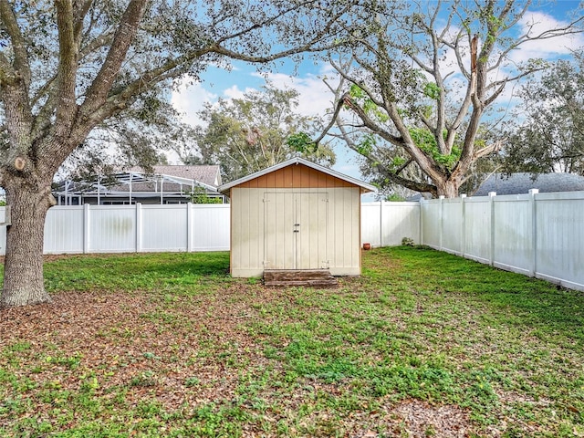 view of yard featuring a storage unit, an outdoor structure, and a fenced backyard