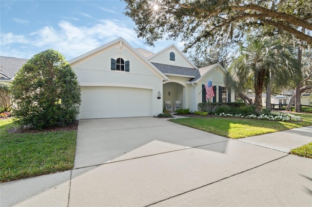 view of front of property featuring an attached garage, a shingled roof, driveway, stucco siding, and a front lawn