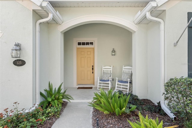 doorway to property featuring stucco siding