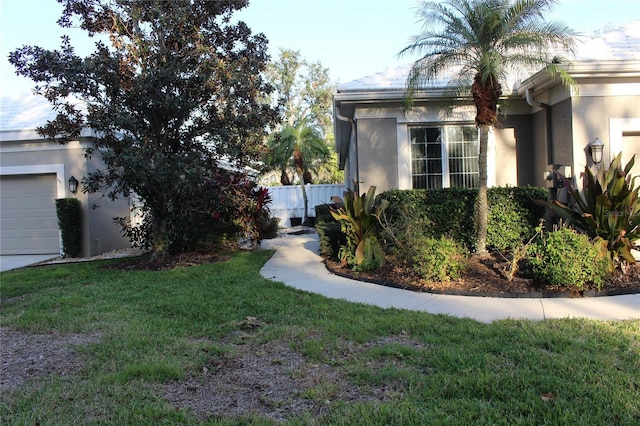 view of side of home featuring a garage and a lawn