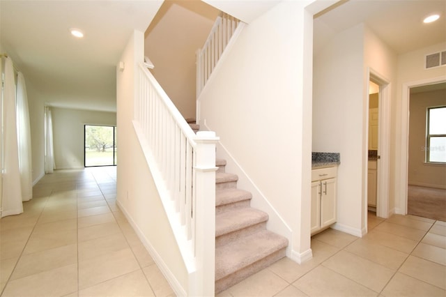 stairway with tile patterned floors and plenty of natural light