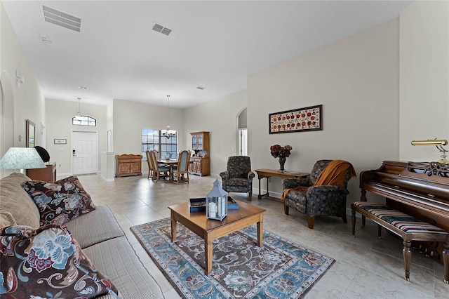 living room with baseboards, visible vents, and arched walkways