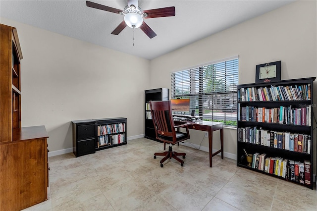 office space with ceiling fan and baseboards