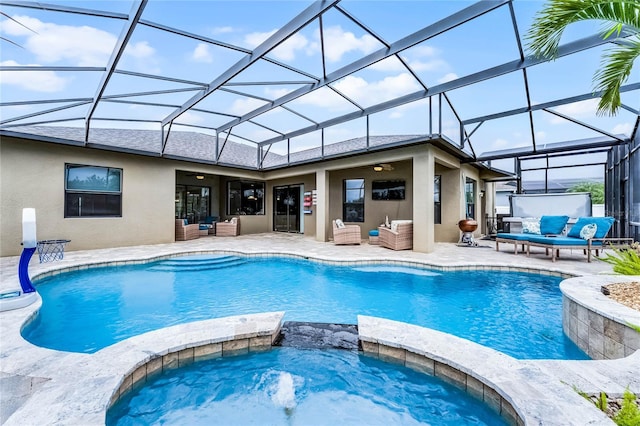 view of pool featuring glass enclosure, a pool with connected hot tub, an outdoor hangout area, and a patio