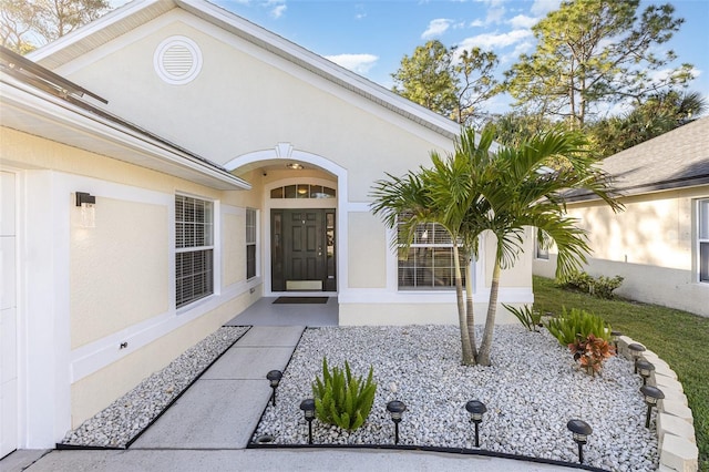 doorway to property featuring stucco siding