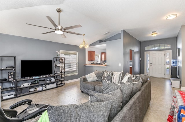 living area with light tile patterned flooring, visible vents, a ceiling fan, vaulted ceiling, and baseboards